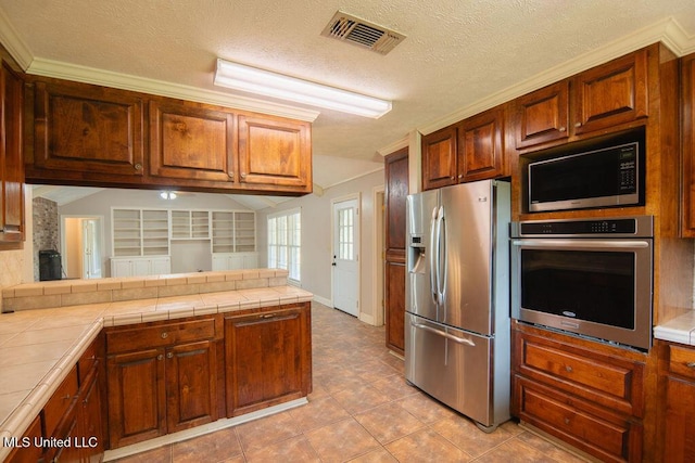 290 Abigail Ln, Bentonia, MS 39040 - kitchen featuring stainless steel appliances, tile counters, visible vents, and a peninsula