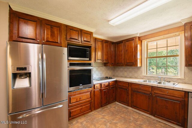 290 Abigail Ln, Bentonia, MS 39040 - kitchen featuring tile counters, appliances with stainless steel finishes, tasteful backsplash, and a sink