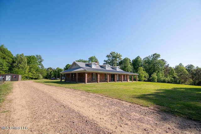 290 Abigail Ln, Bentonia, MS 39040 - farmhouse-style home with an outbuilding, a front lawn, brick siding, dirt driveway, and a forest view