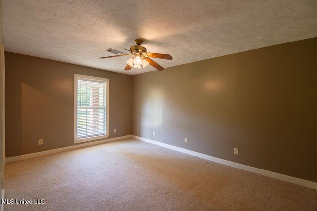 290 Abigail Ln, Bentonia, MS 39040 - spare room with visible vents, a ceiling fan, light carpet, baseboards, and a textured ceiling