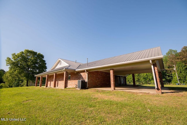 290 Abigail Ln, Bentonia, MS 39040 - view of home's exterior with central air condition unit, an attached carport, a yard, metal roof, and brick siding
