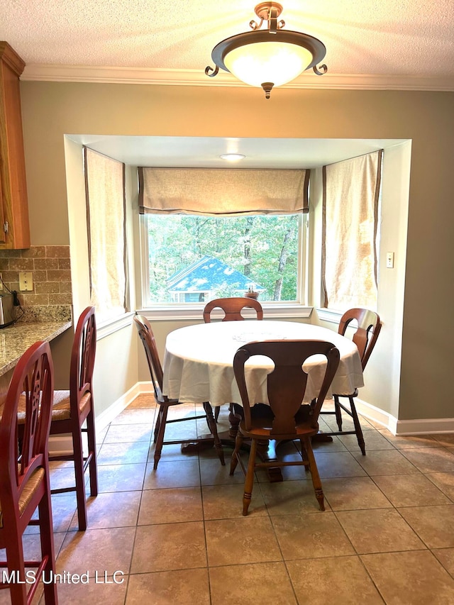 dining area with crown molding, tile patterned floors, and a textured ceiling