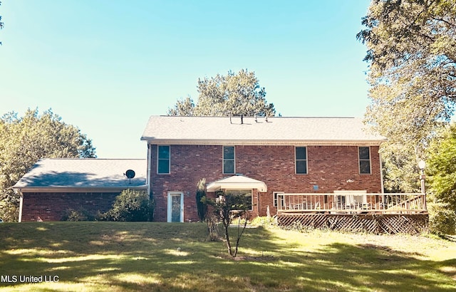 back of property featuring a deck and a lawn