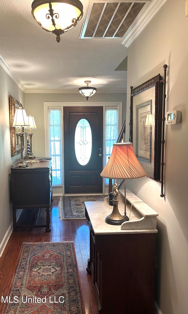 entrance foyer featuring crown molding, a textured ceiling, dark hardwood / wood-style flooring, and plenty of natural light