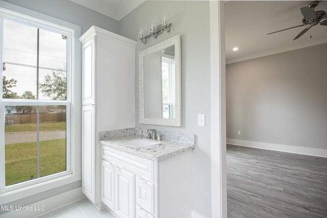 bathroom featuring vanity, ceiling fan, crown molding, and wood-type flooring