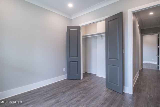 unfurnished bedroom featuring crown molding, dark hardwood / wood-style floors, and a closet