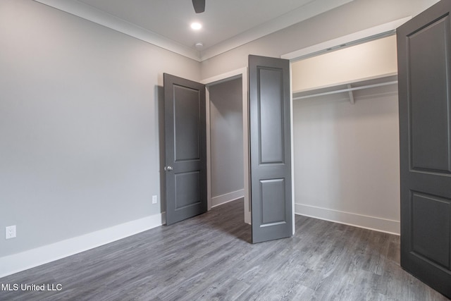 unfurnished bedroom featuring dark hardwood / wood-style floors, a closet, and ceiling fan