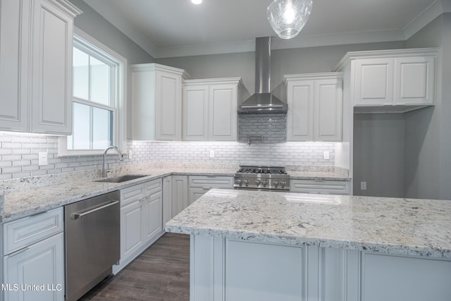 kitchen featuring appliances with stainless steel finishes, sink, white cabinetry, wall chimney exhaust hood, and pendant lighting