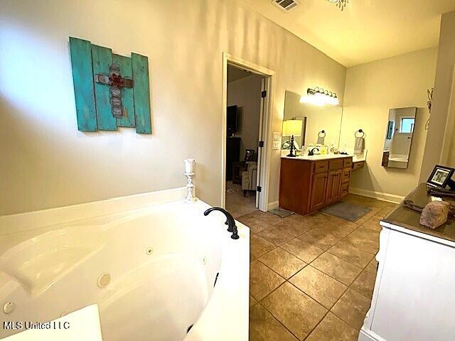 771 Robertson Way, Hernando, MS 38632 - bathroom with vanity, a jetted tub, and tile patterned flooring