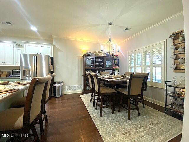 771 Robertson Way, Hernando, MS 38632 - dining space featuring a chandelier, crown molding, and dark wood-style floors