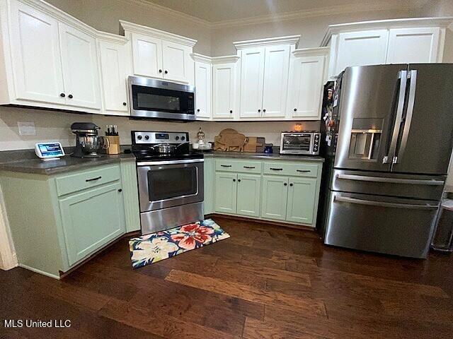771 Robertson Way, Hernando, MS 38632 - kitchen with stainless steel appliances, crown molding, dark wood finished floors, white cabinets, and dark countertops