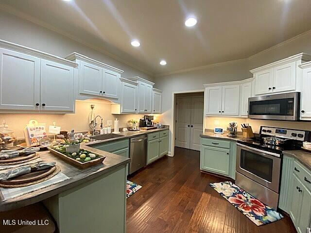 771 Robertson Way, Hernando, MS 38632 - kitchen featuring appliances with stainless steel finishes, green cabinetry, crown molding, dark wood-style floors, and recessed lighting