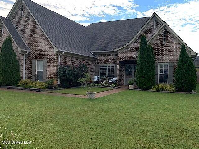 771 Robertson Way, Hernando, MS 38632 - view of front facade featuring brick siding, a front yard, and roof with shingles