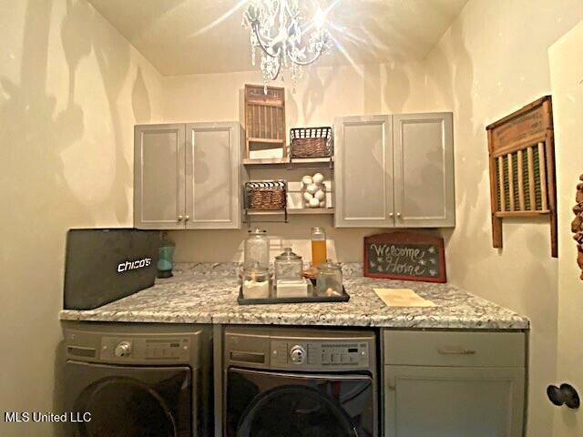 771 Robertson Way, Hernando, MS 38632 - laundry room with washer and clothes dryer, cabinet space, and a chandelier