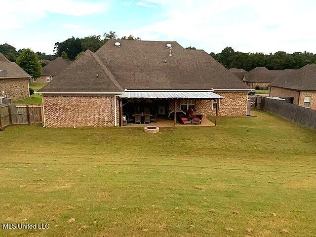 771 Robertson Way, Hernando, MS 38632 - back of property with a fenced backyard, an outdoor fire pit, a patio area, and brick siding