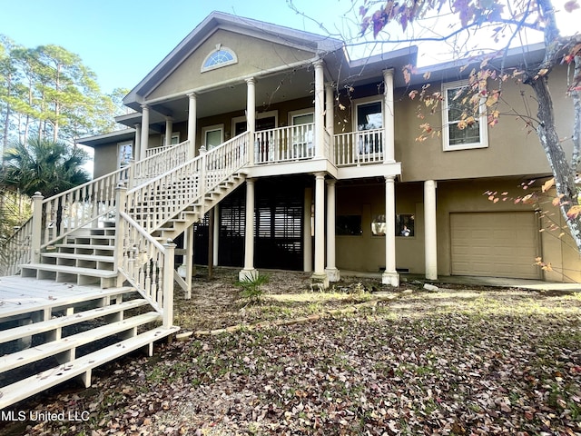 6301 Mary Mahoney Dr, Ocean Springs, MS 39564 - rear view of house featuring stairs, stucco siding, an attached garage, and a porch
