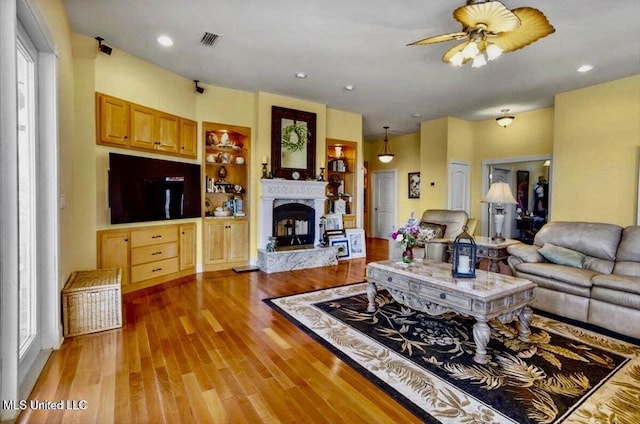 6301 Mary Mahoney Dr, Ocean Springs, MS 39564 - living area featuring ceiling fan, light wood-style flooring, and a premium fireplace