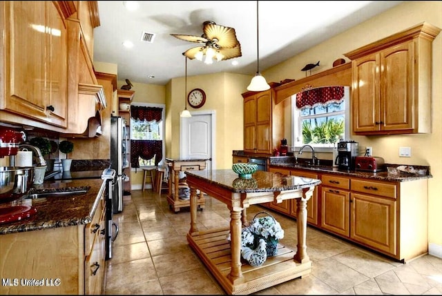 6301 Mary Mahoney Dr, Ocean Springs, MS 39564 - kitchen with freestanding refrigerator, ceiling fan, dark stone counters, a sink, and light tile patterned floors