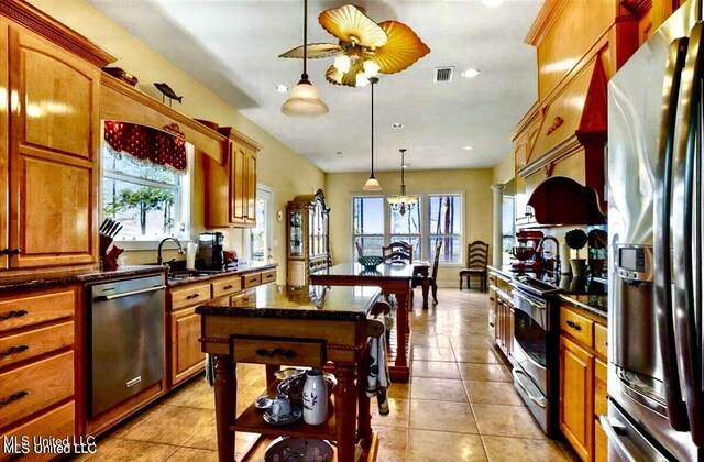6301 Mary Mahoney Dr, Ocean Springs, MS 39564 - kitchen with appliances with stainless steel finishes, a center island, a sink, light tile patterned flooring, and pendant lighting