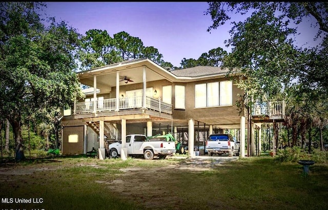 6301 Mary Mahoney Dr, Ocean Springs, MS 39564 - rear view of house featuring a carport, driveway, ceiling fan, stairs, and stucco siding
