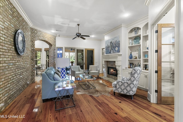 living room with brick wall and hardwood / wood-style flooring