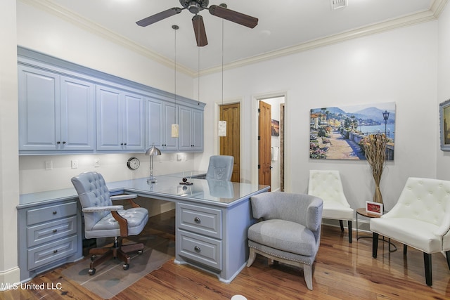 office area with crown molding, built in desk, ceiling fan, and dark wood-type flooring