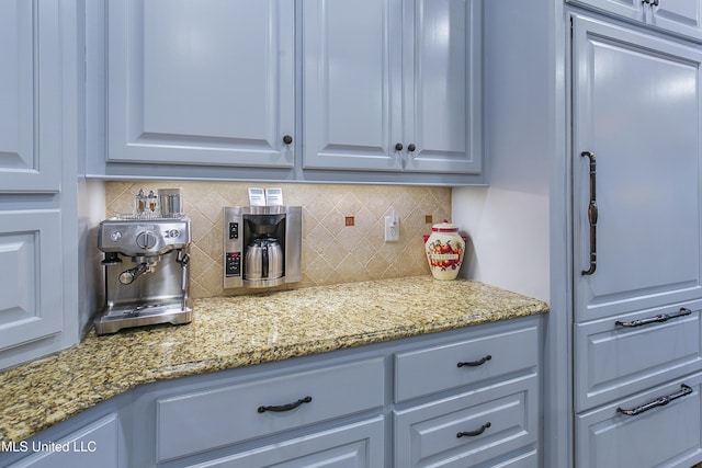 kitchen with backsplash, gray cabinets, and light stone counters