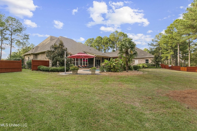 rear view of property featuring a patio area and a lawn