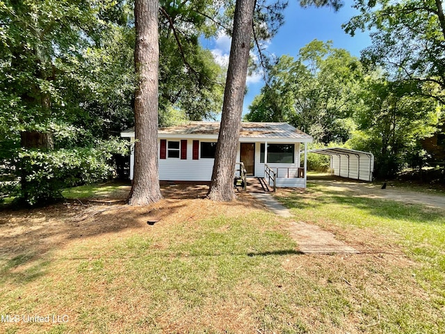 view of front facade with a front yard, covered porch, and a carport