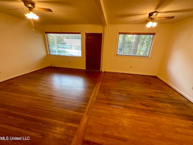 unfurnished room with a textured ceiling, a healthy amount of sunlight, hardwood / wood-style flooring, and ceiling fan