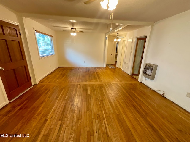 unfurnished room with hardwood / wood-style flooring, heating unit, and ceiling fan