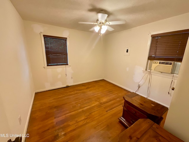 spare room with cooling unit, wood-type flooring, and ceiling fan