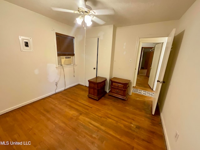 unfurnished bedroom featuring cooling unit, hardwood / wood-style flooring, and ceiling fan