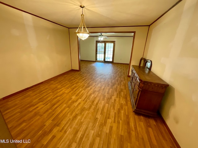 empty room featuring light hardwood / wood-style flooring, ornamental molding, french doors, and ceiling fan