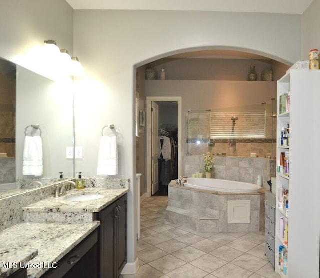 8146 Wisteria Dr, Olive Branch, MS 38654 - bathroom with tile patterned flooring, a garden tub, vanity, and a spacious closet