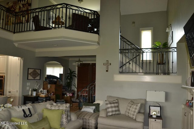 8146 Wisteria Dr, Olive Branch, MS 38654 - living area featuring stairs, arched walkways, healthy amount of natural light, a high ceiling, and crown molding