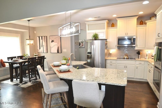 8146 Wisteria Dr, Olive Branch, MS 38654 - kitchen featuring stainless steel appliances, backsplash, dark wood-style flooring, light stone countertops, and recessed lighting