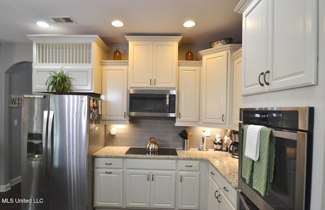8146 Wisteria Dr, Olive Branch, MS 38654 - kitchen with appliances with stainless steel finishes, white cabinets, backsplash, and light stone countertops