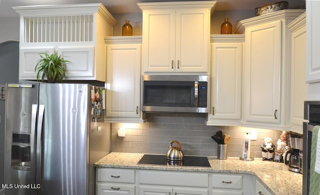 8146 Wisteria Dr, Olive Branch, MS 38654 - kitchen with appliances with stainless steel finishes, decorative backsplash, white cabinetry, and light stone countertops