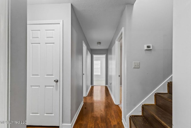 hall with stairway, wood finished floors, and baseboards
