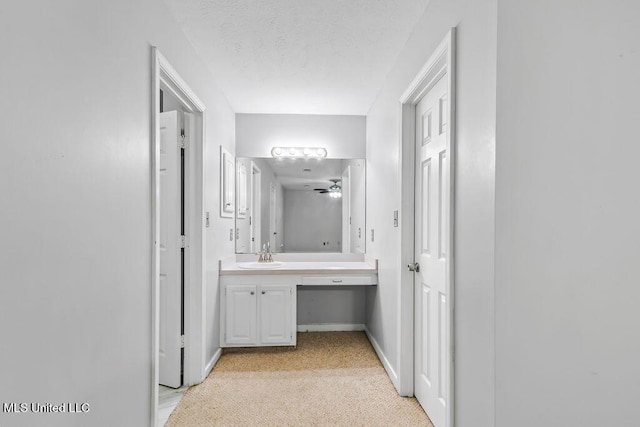 bathroom with vanity, a textured ceiling, and baseboards