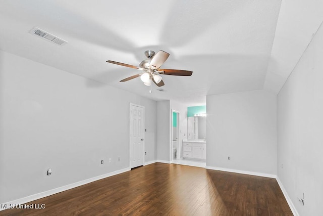 unfurnished bedroom with baseboards, ensuite bathroom, visible vents, and wood finished floors