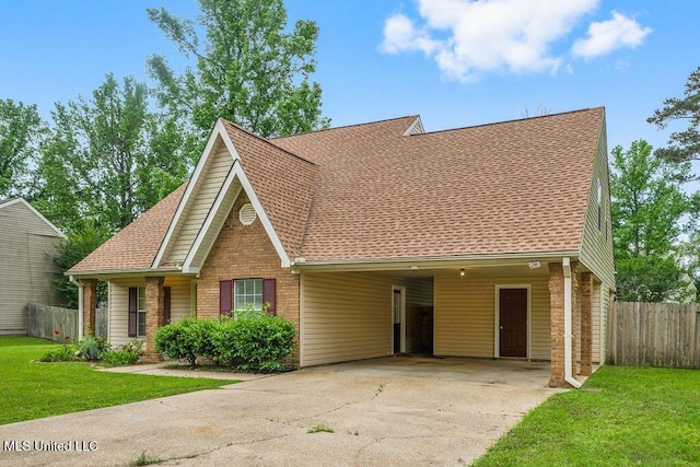 view of front of property featuring roof with shingles, fence, a front yard, and driveway
