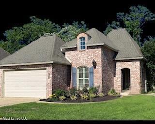 3808 Acadian Village Dr, Ocean Springs, MS 39564 - view of front of home featuring an attached garage, a front yard, driveway, and stone siding