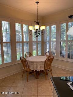 3808 Acadian Village Dr, Ocean Springs, MS 39564 - dining space featuring light tile patterned flooring, healthy amount of natural light, a chandelier, and baseboards