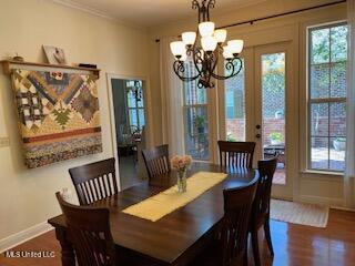 3808 Acadian Village Dr, Ocean Springs, MS 39564 - dining area featuring a chandelier, baseboards, wood finished floors, and ornamental molding