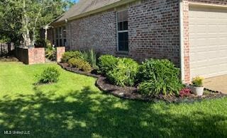 3808 Acadian Village Dr, Ocean Springs, MS 39564 - view of property exterior featuring an attached garage, a yard, and brick siding