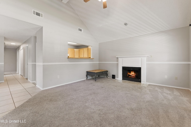 unfurnished living room with ceiling fan, high vaulted ceiling, and light tile patterned floors