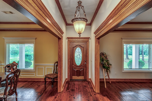 foyer entrance with a wealth of natural light, ornamental molding, and dark wood-type flooring