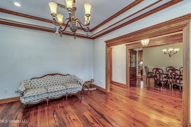 sitting room featuring ornamental molding, a notable chandelier, and hardwood / wood-style flooring